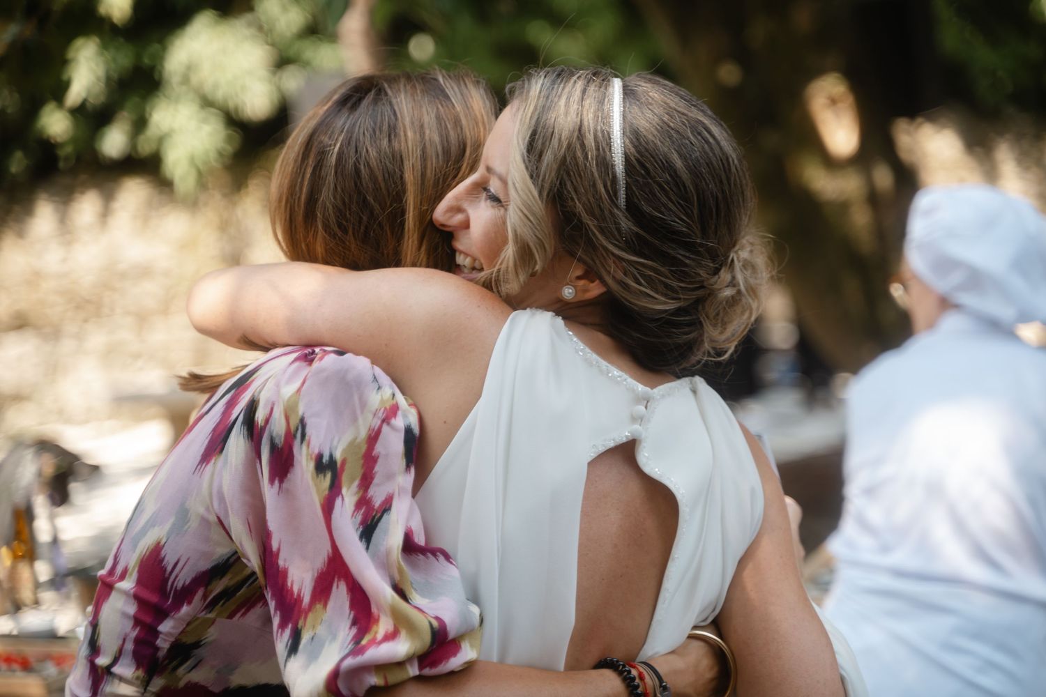 Wedding party members in colorful attire celebrate during an outdoor summer celebration.