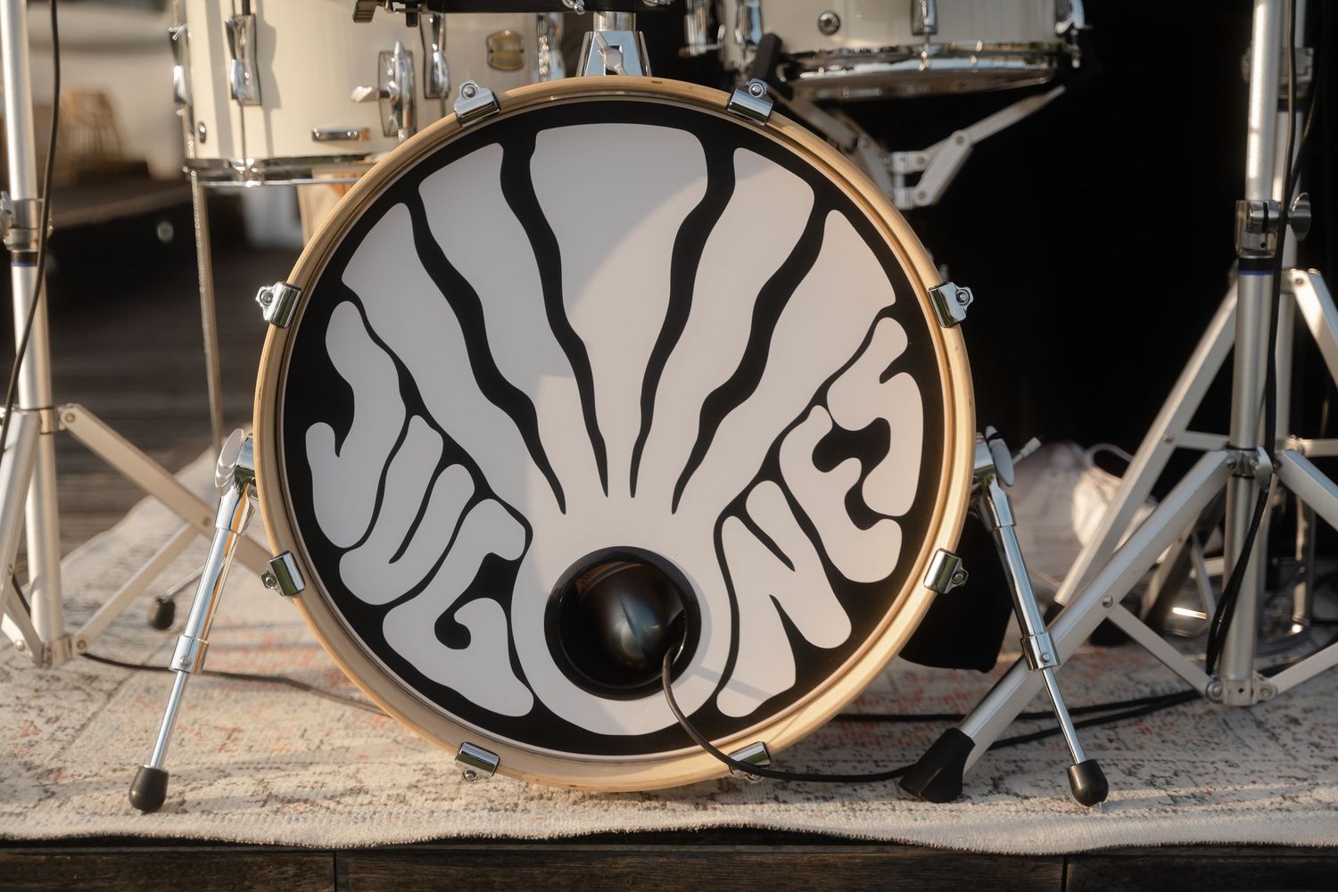 A series of five black and white drum heads arranged in a row showing decorative swirling patterns and designs.