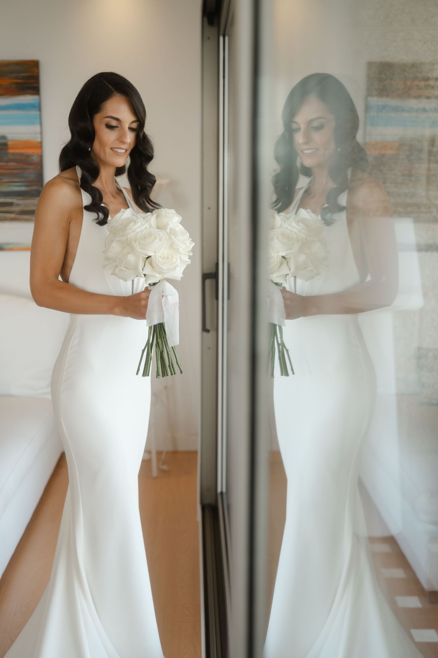 Elegant white wedding gown with fitted silhouette and floral detail at neckline shown in multiple reflective angles.