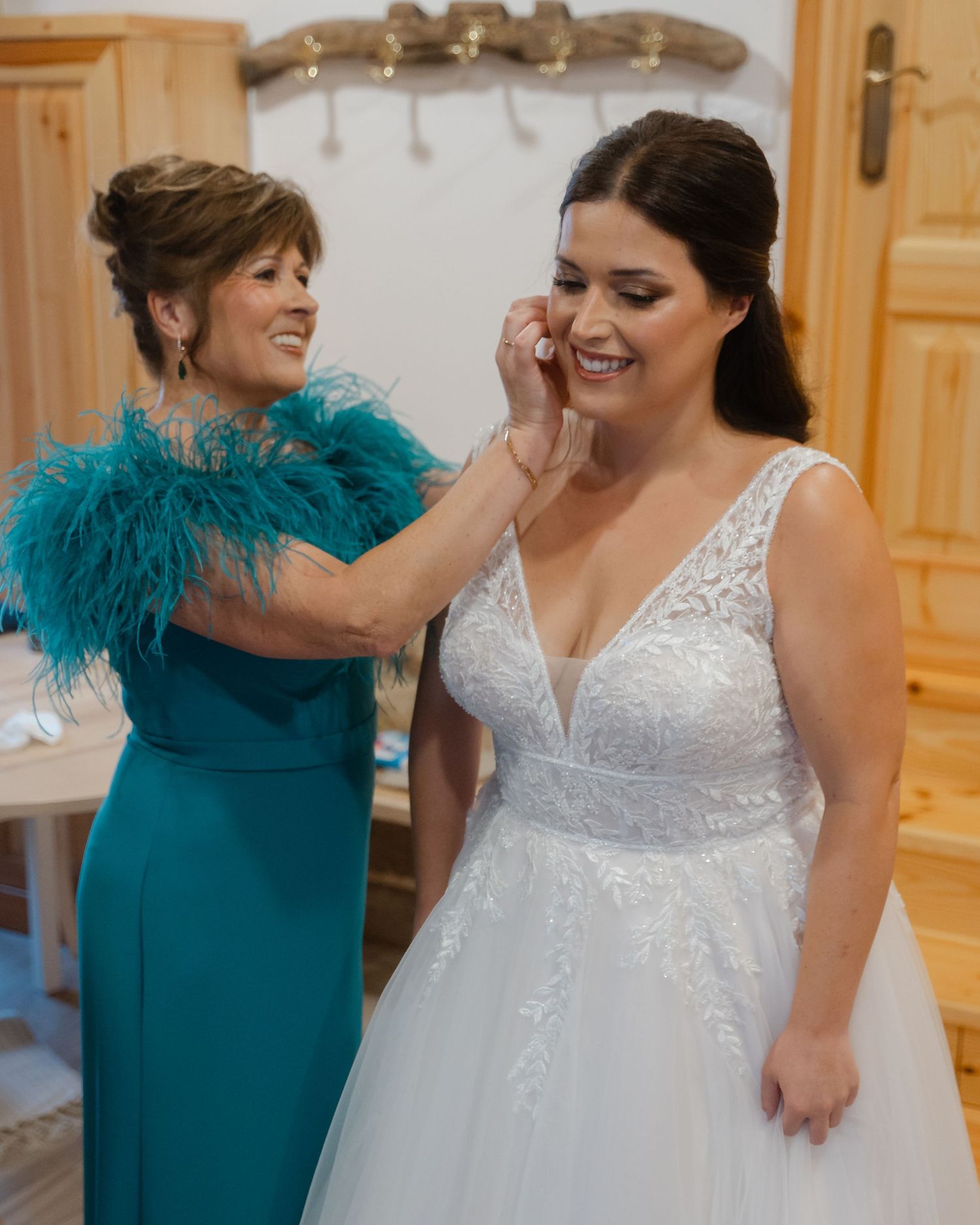 Bridesmaids in elegant teal dresses share joyful moments with the bride in a white lace gown at a wedding celebration.