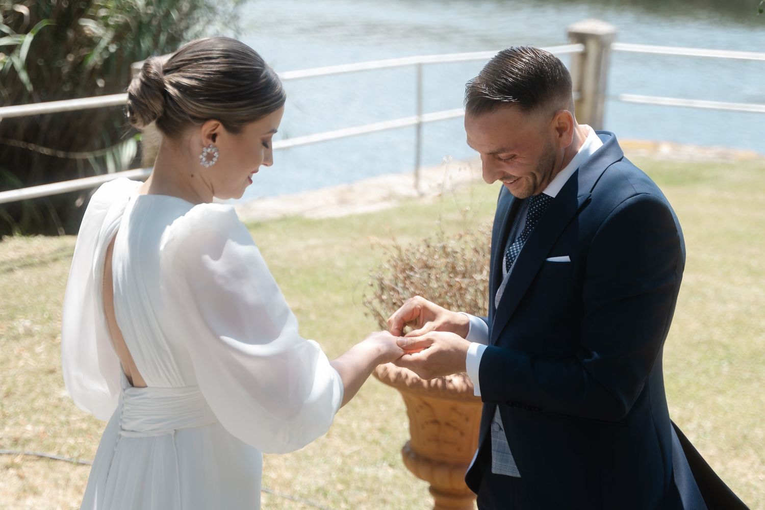 A couple exchanges rings during an intimate outdoor wedding ceremony.