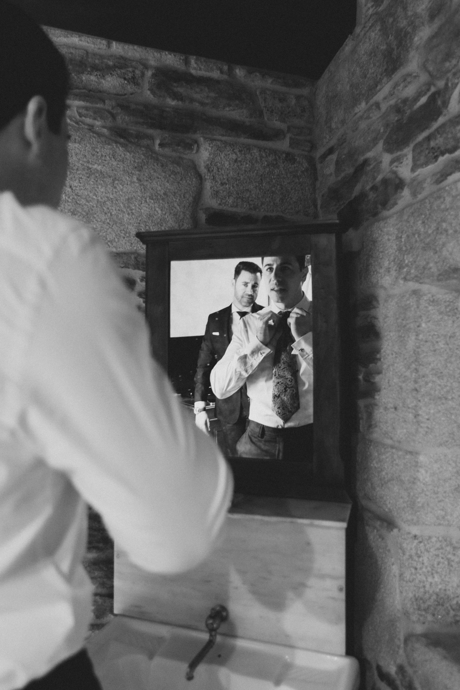 Black and white photos showing reflections in a mirror as someone adjusts their formal attire.