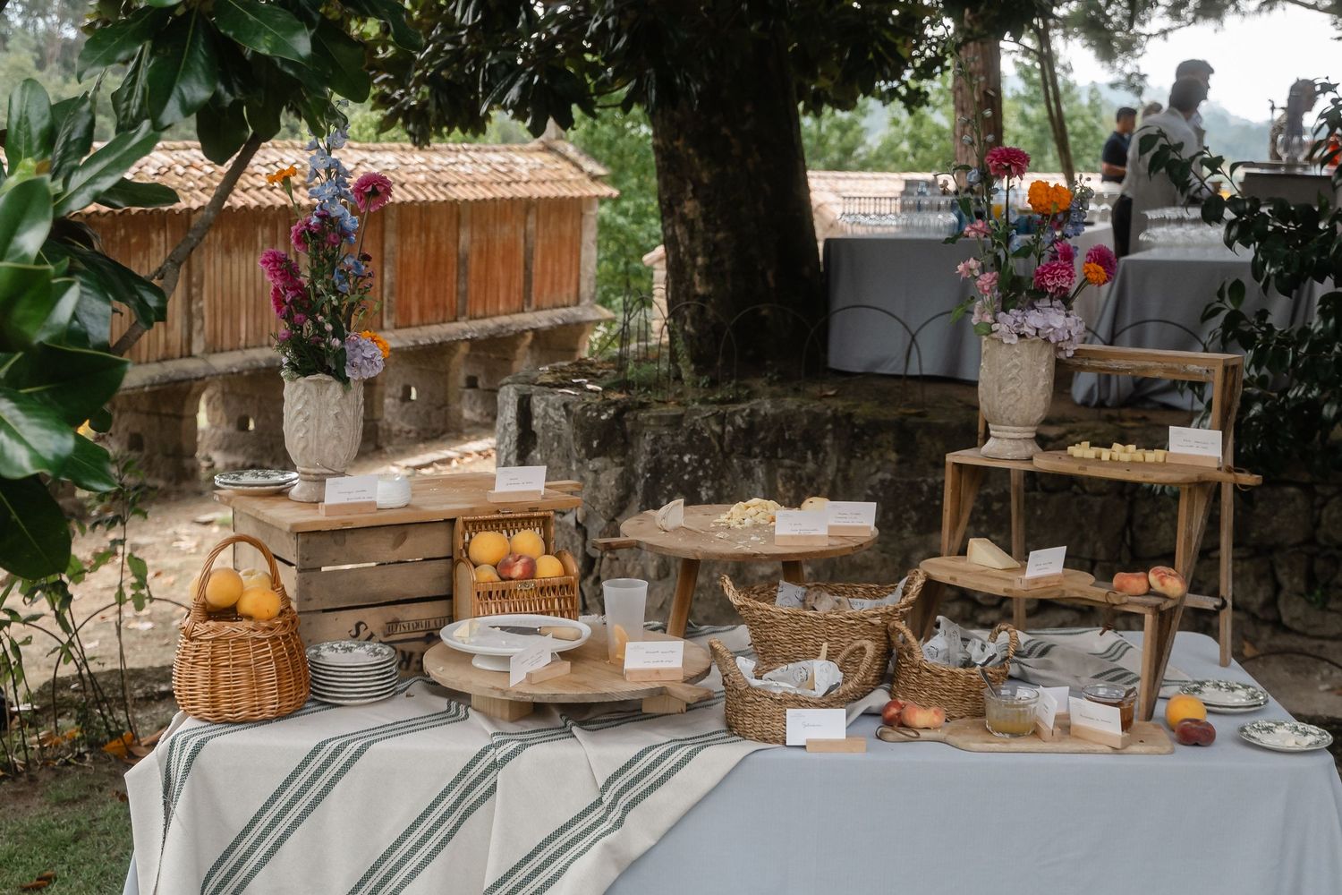 Rustic outdoor wedding reception table settings with wooden decor and vintage lanterns in a garden setting.