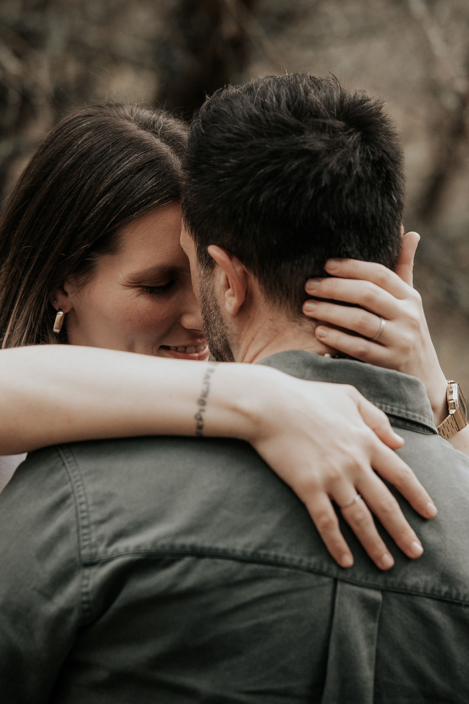 An intimate embrace captured in moody lighting showing a close romantic moment between a couple.