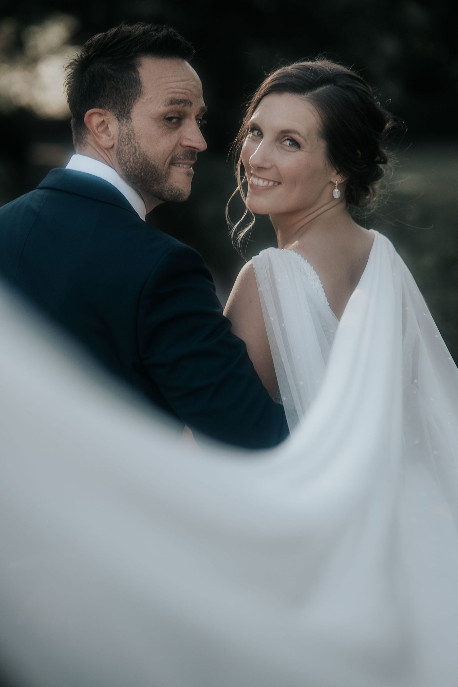 Intimate wedding moment captured in sequence with bride's veil creating graceful movement.