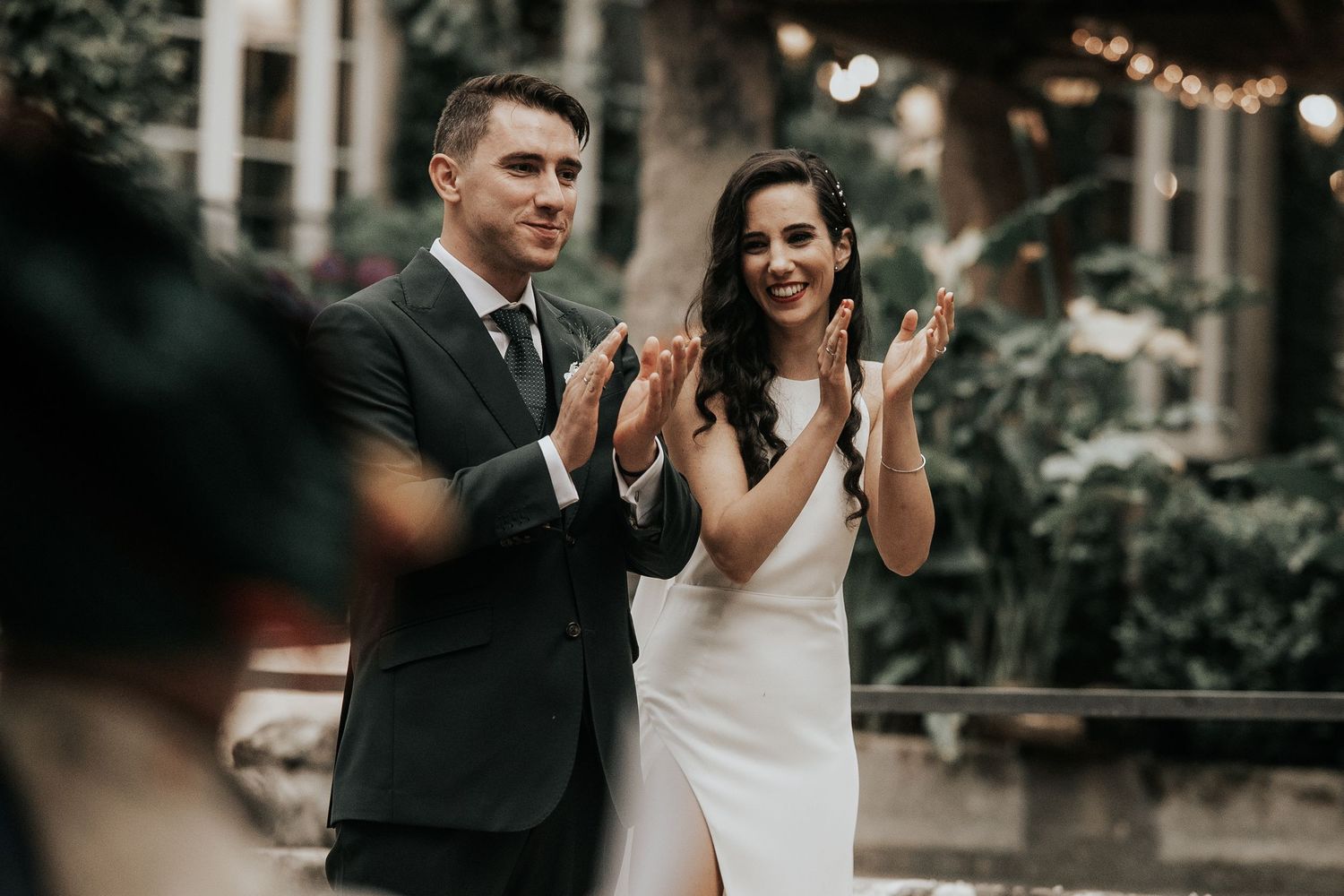 A couple celebrates their wedding day in an intimate outdoor garden setting with natural lighting and lush greenery.