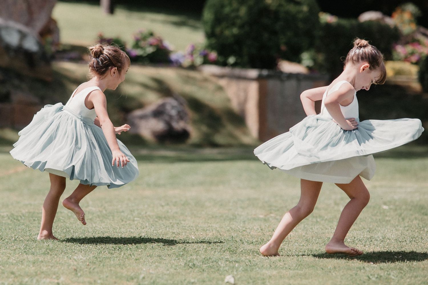 A sequence of flowing dress movements captured in motion as someone twirls and dances on a grassy lawn.
