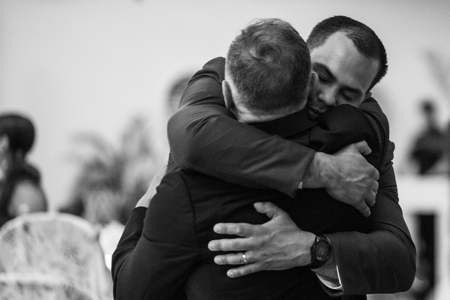 A black and white collage of intimate moments showing people embracing in tender hugs and gestures of affection.