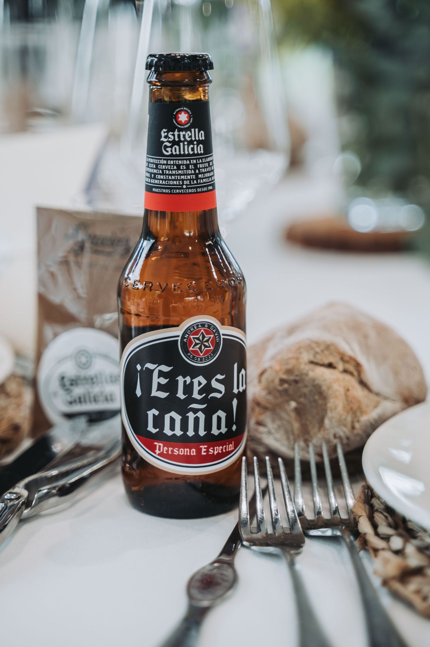 Close-up shots of Spanish beer bottles including Estrella Galicia and Caña on a dining table with place settings.