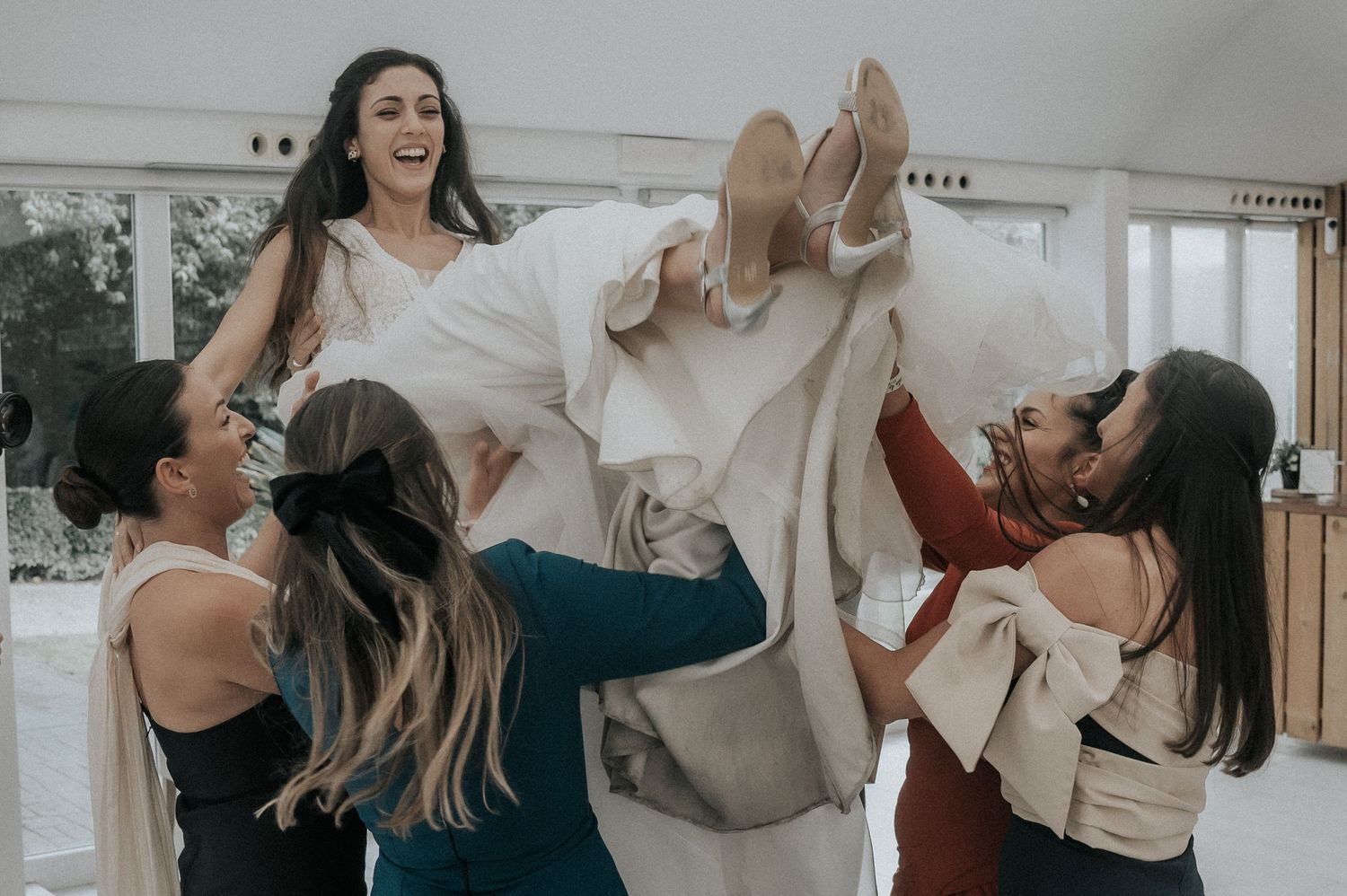 A sequence of candid photos showing joyful people dancing and laughing together in a bright indoor setting.