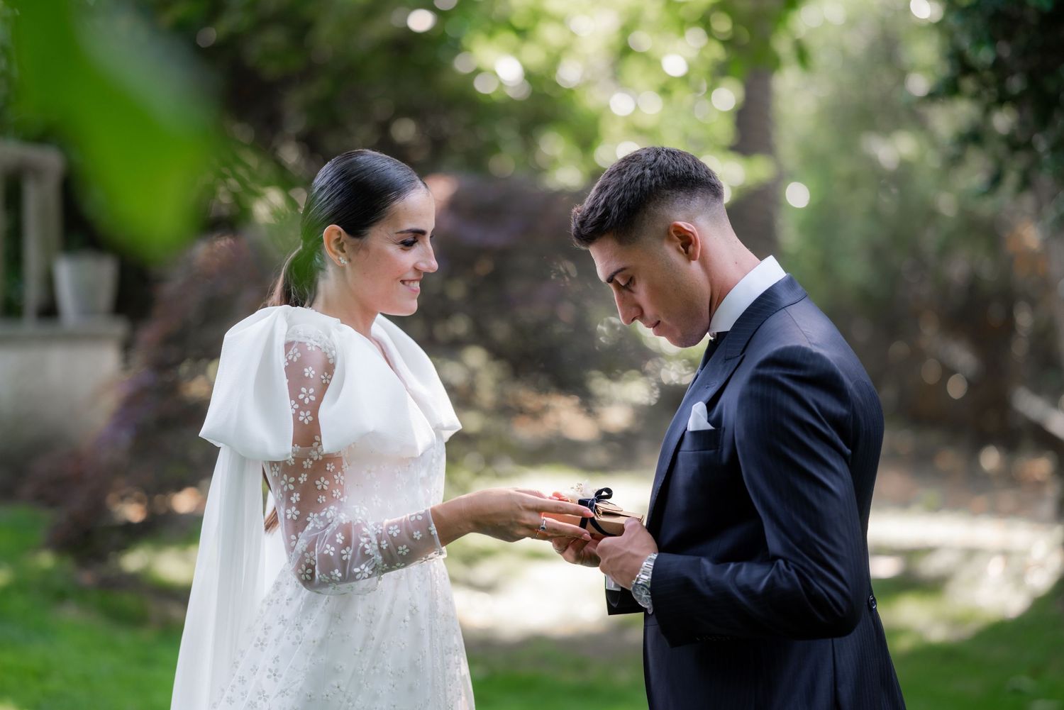 Bride and groom share an intimate moment outdoors during their wedding ceremony in a garden setting.