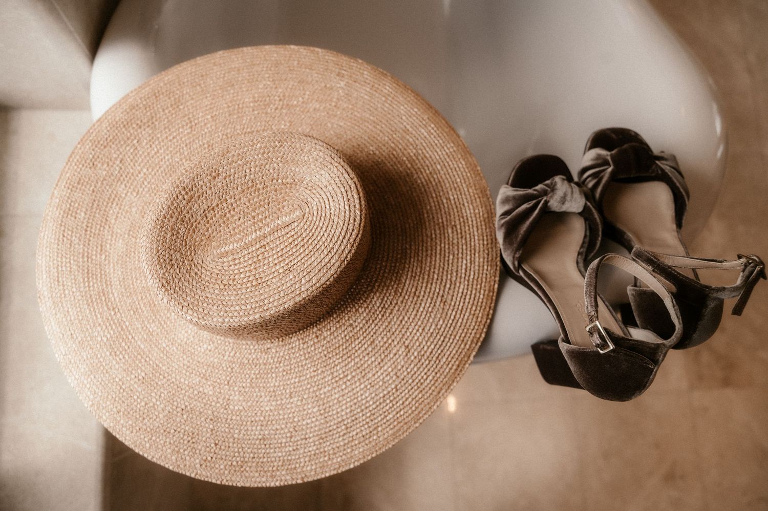 Beige straw sun hat with black ribbon band displayed in multiple angles against a neutral background.