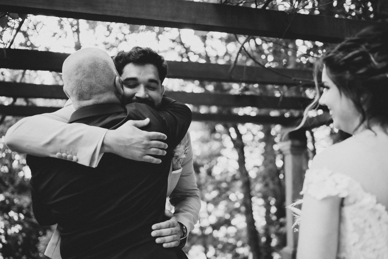 Black and white photo capturing emotional reactions during an outdoor wedding ceremony.