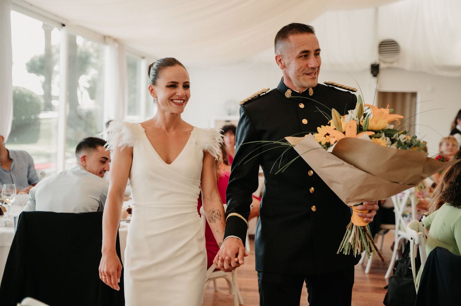 A couple shares their first dance at an elegant wedding reception with guests watching.