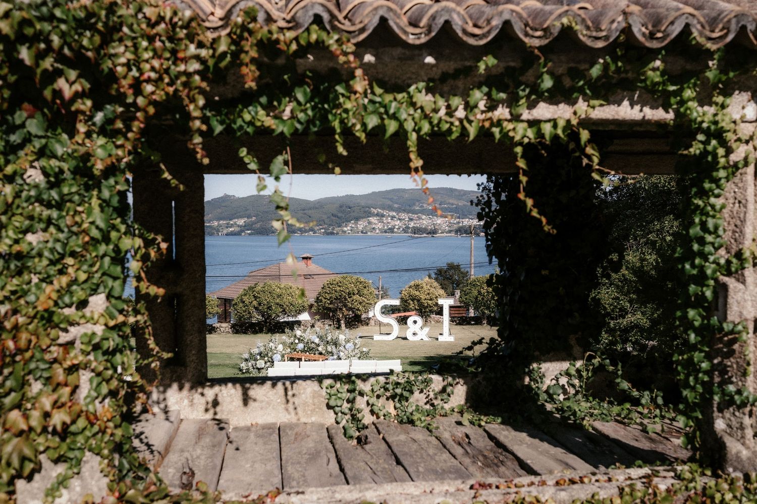 A series of wooden decks and walkways with ocean views lead down to a waterfront area surrounded by lush vegetation.