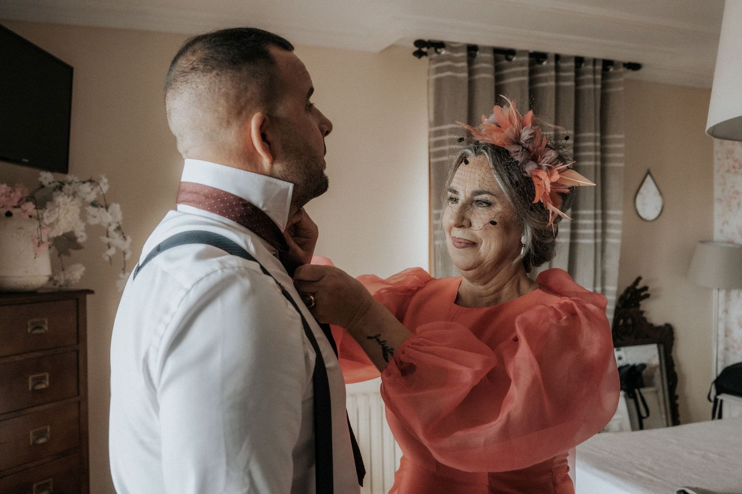 A couple in formal attire dances together in a bright indoor space with a romantic atmosphere.