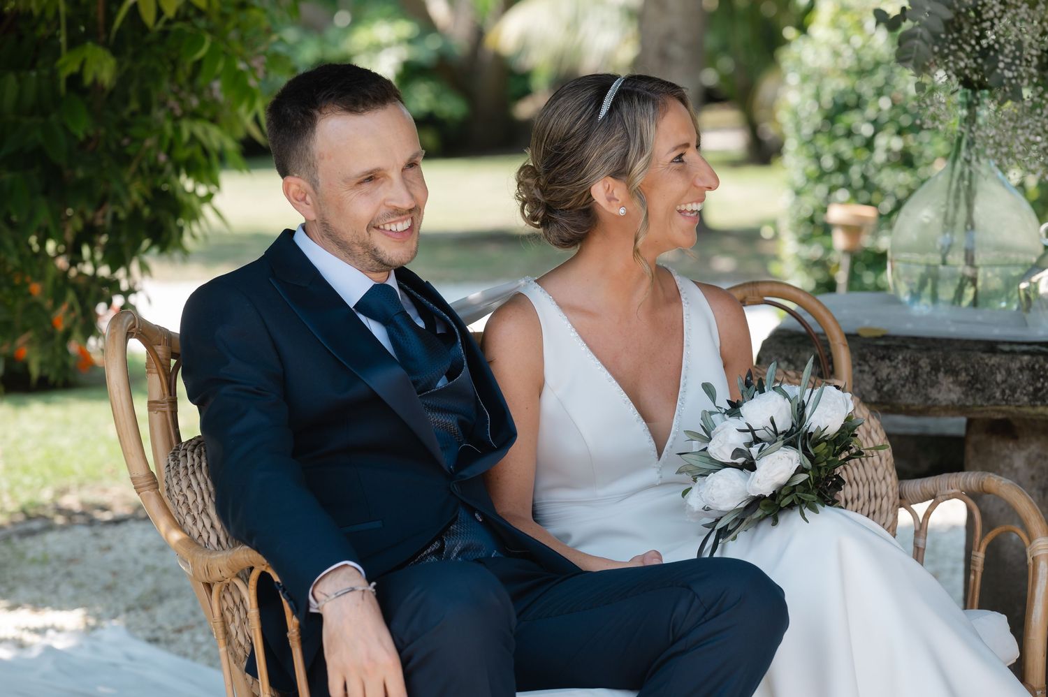 A happy couple shares joyful moments together in an outdoor garden setting during their wedding celebration.