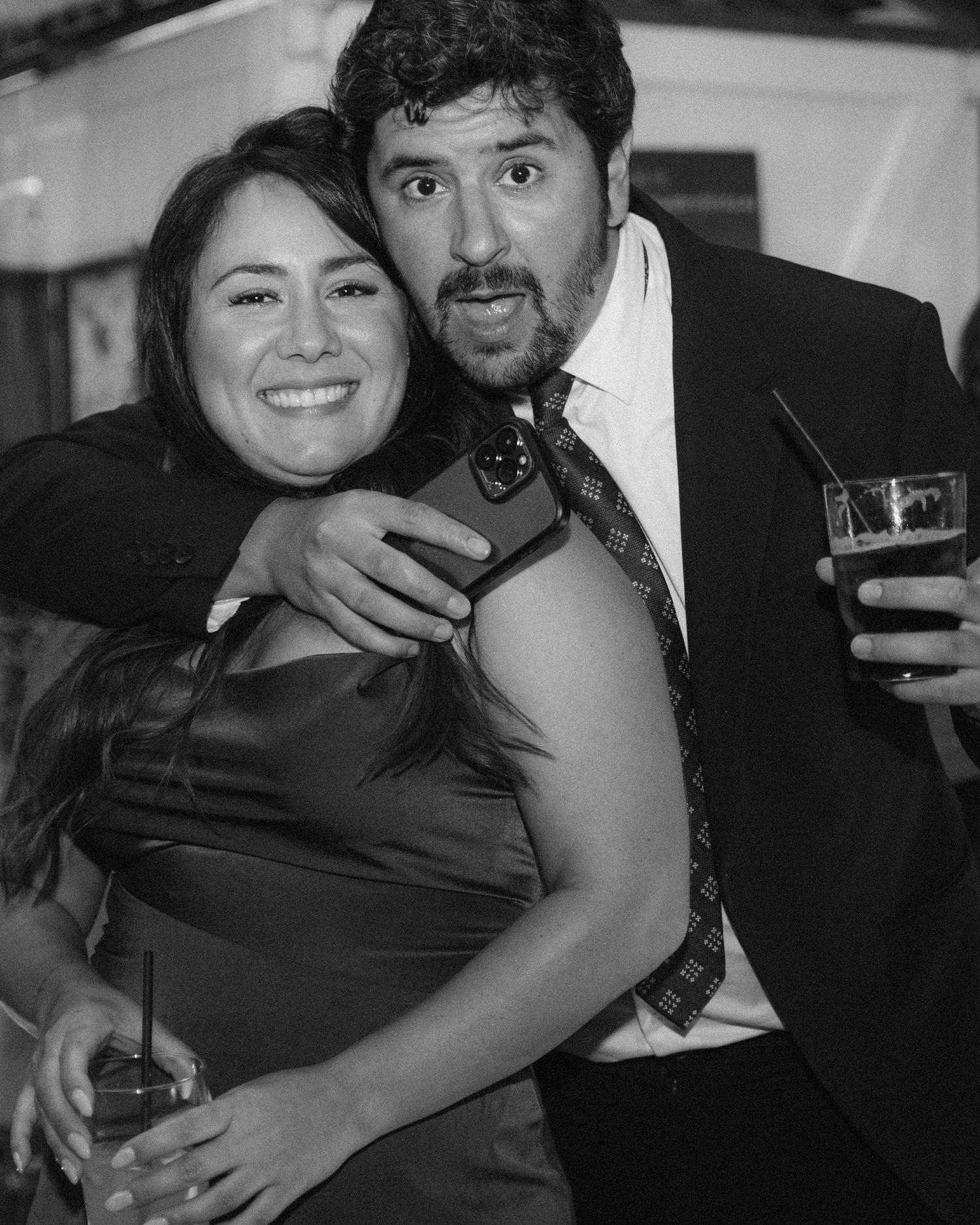 A series of candid black and white party photos showing people embracing and celebrating together.
