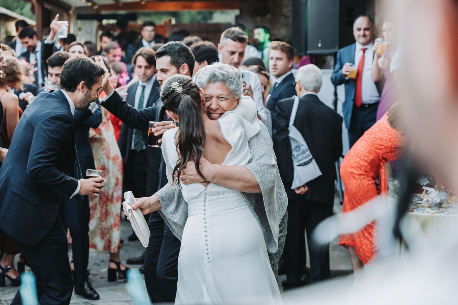 Wedding celebration with guests dancing and celebrating at an outdoor reception.
