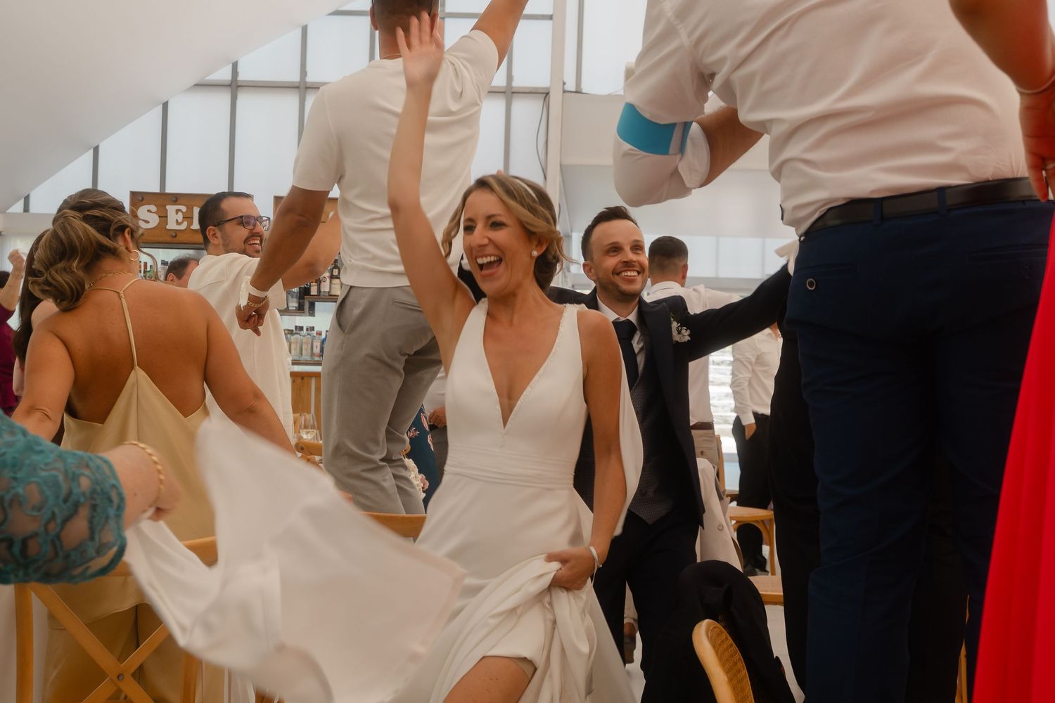 Guests celebrate and dance together during a lively wedding reception party.