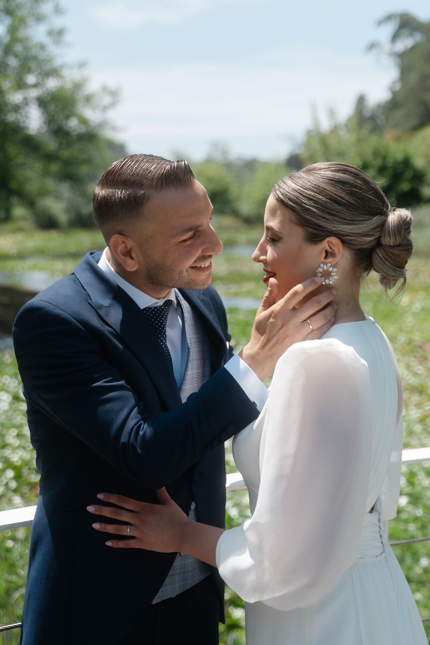 Romantic wedding couple shares intimate moments in a garden setting with white flowers.