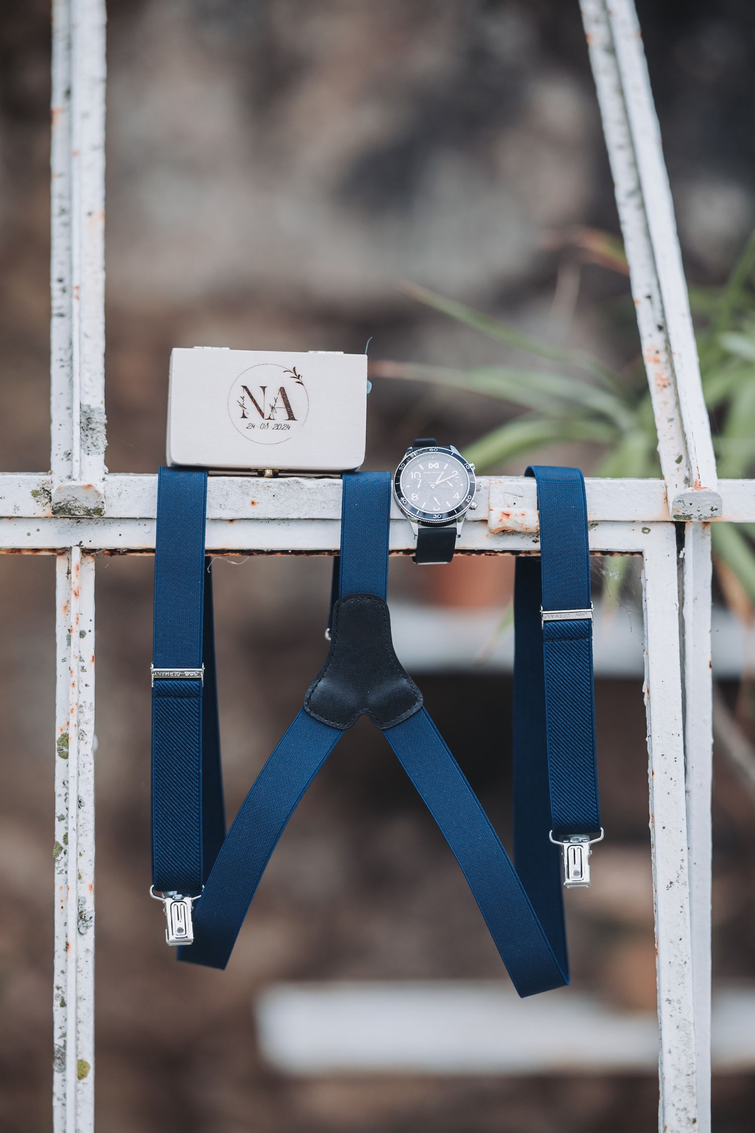 Navy blue bow ties hang in a row on white metal bars creating an elegant display.