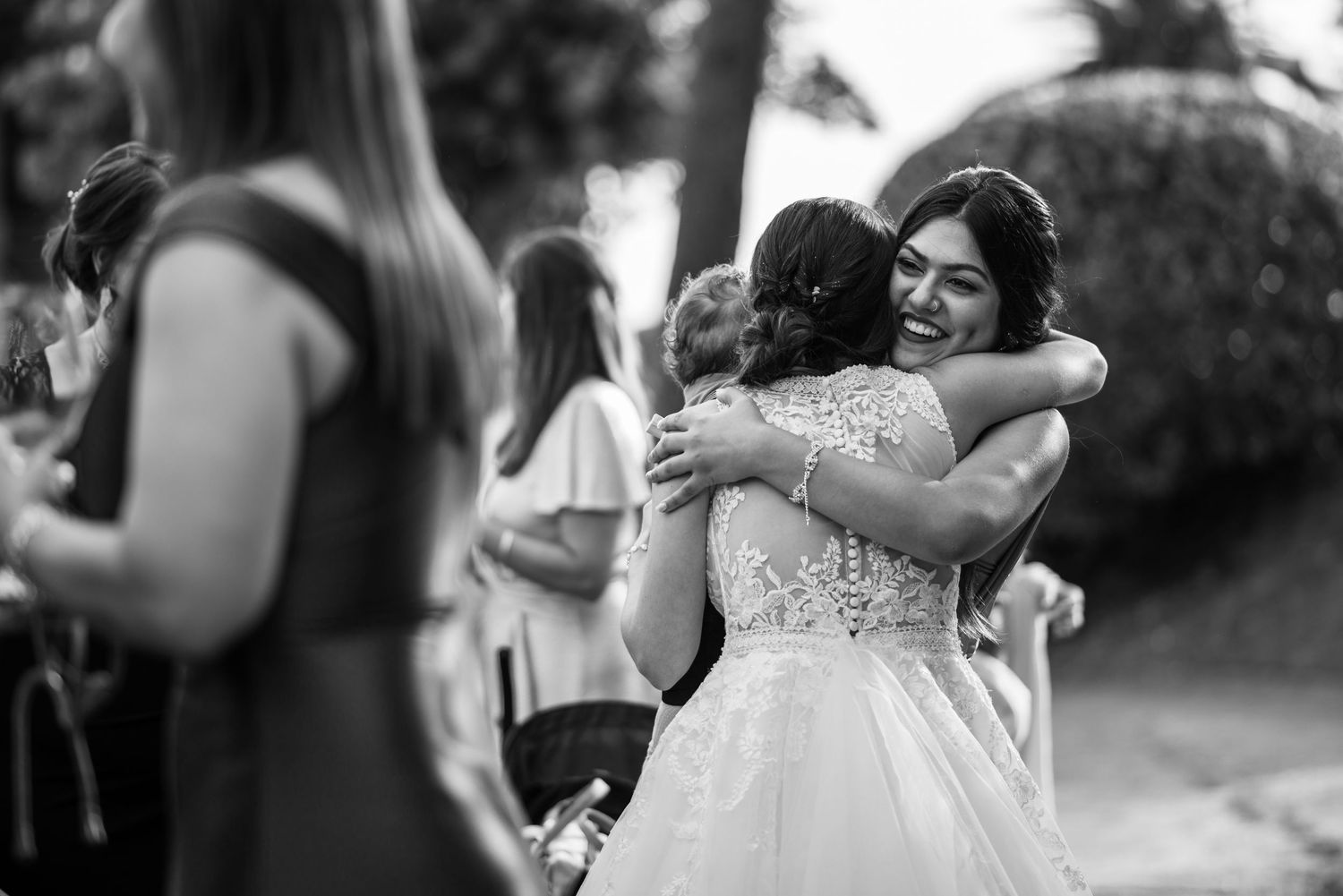 A series of black and white wedding photos showing intimate moments and embraces between couples at their celebration.