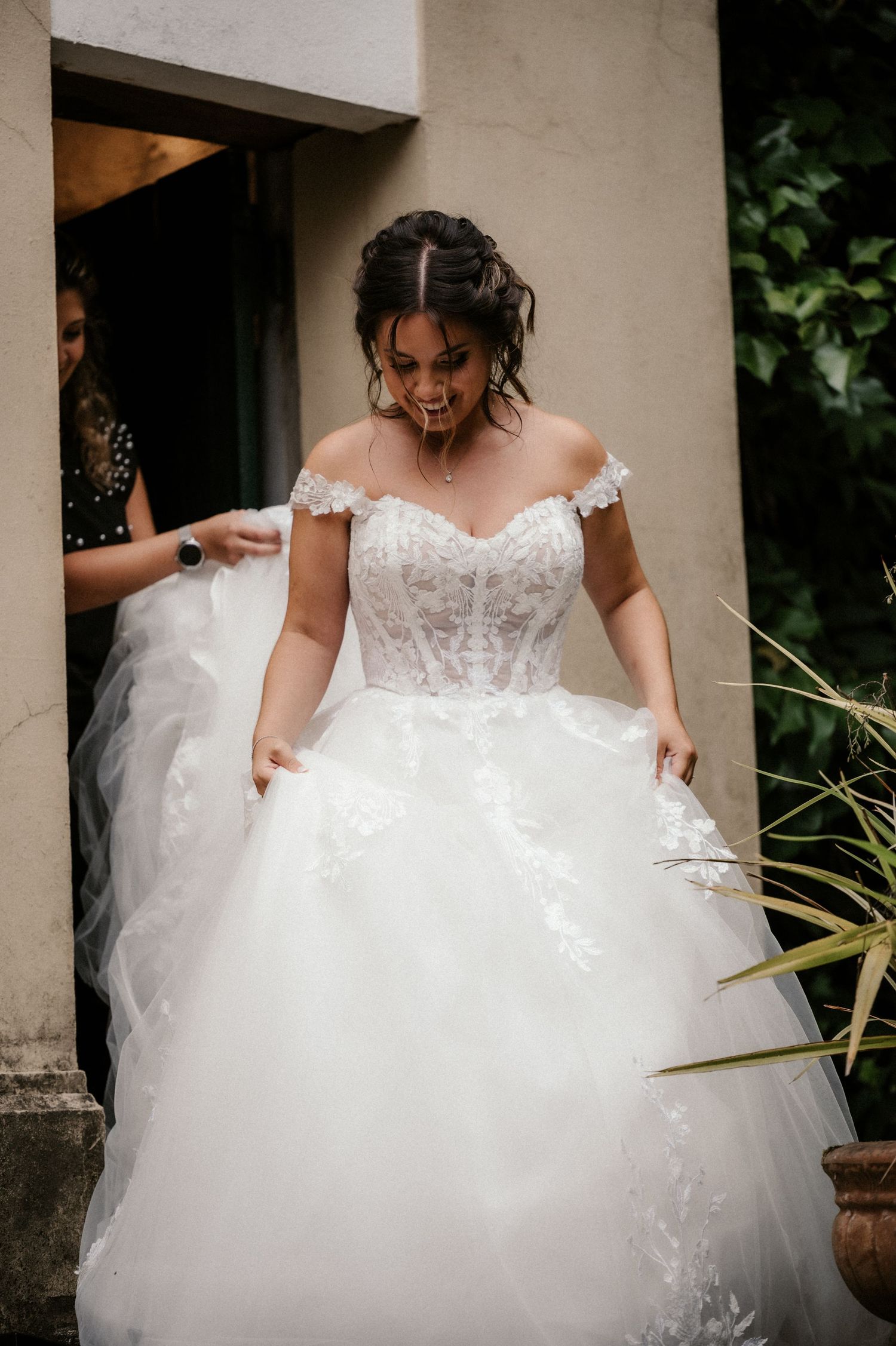 A series of photos showing the delicate details of a white lace wedding dress with a flowing tulle skirt.