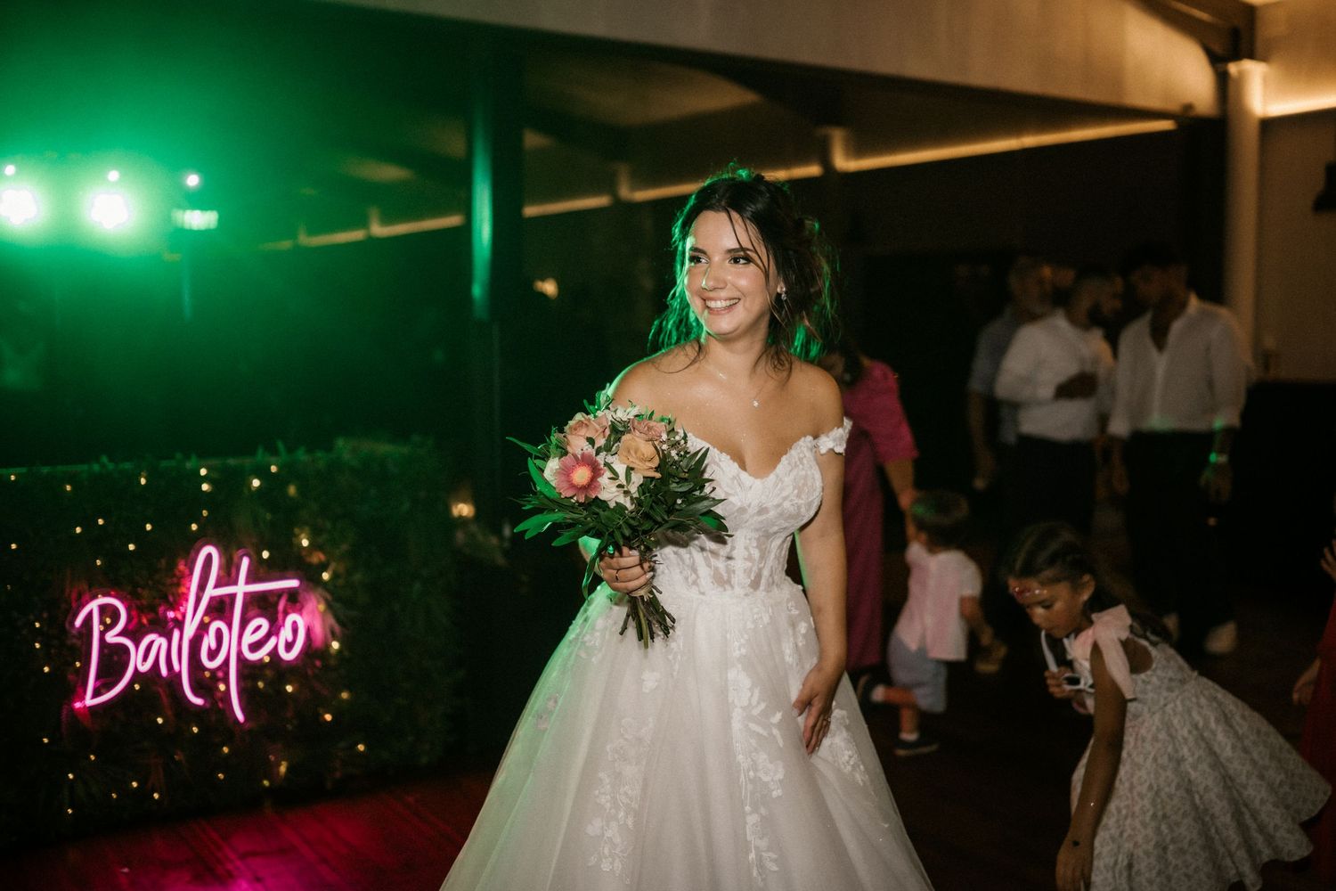 A wedding reception venue illuminated with vibrant green lighting creates a dramatic atmosphere for celebration.