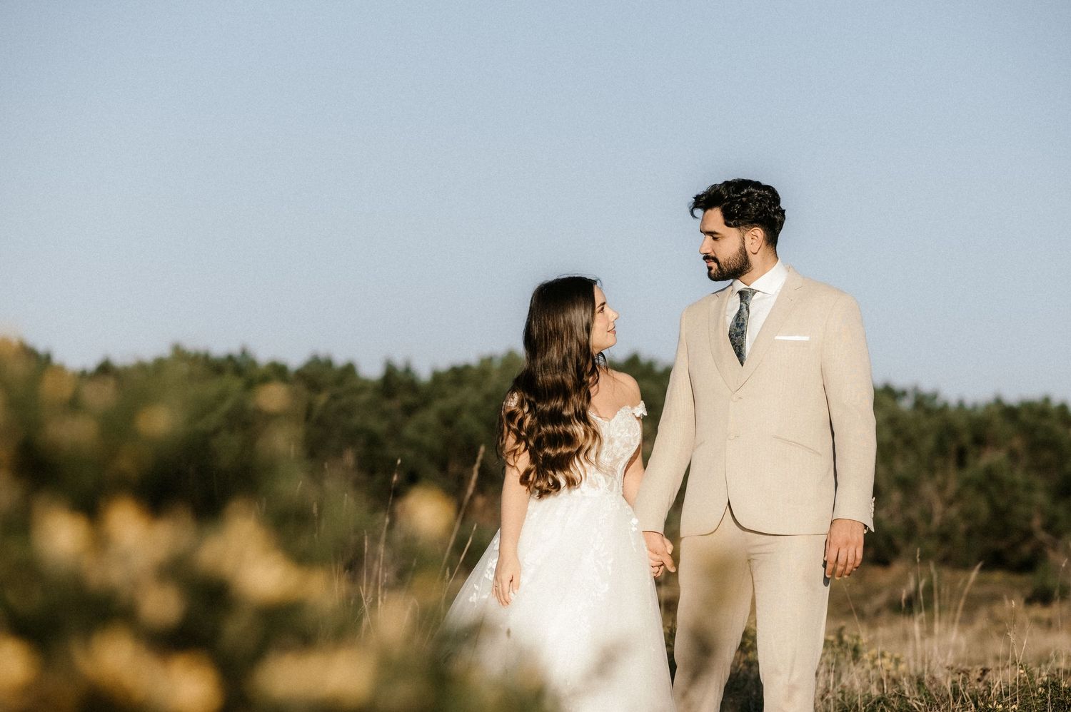 A panoramic series of wedding photos showing a couple in formal attire against a blue sky.