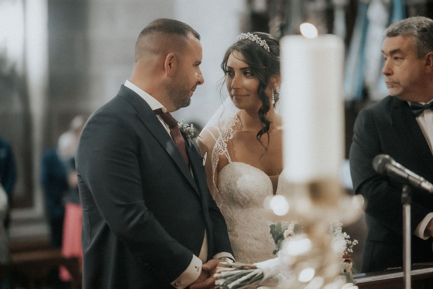 Newlyweds exchange emotional vows during their wedding ceremony surrounded by candlelight and guests.