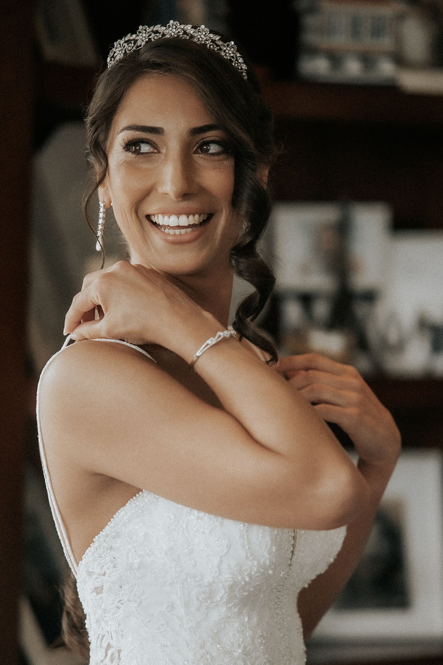 A white lace wedding dress with sweetheart neckline sparkles in warm indoor lighting.