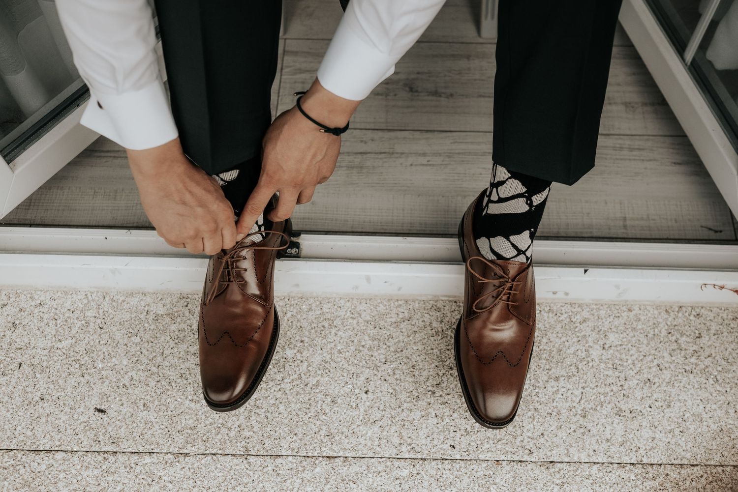 Close-up view of brown leather dress shoes on a light gray floor showing different angles and positions.