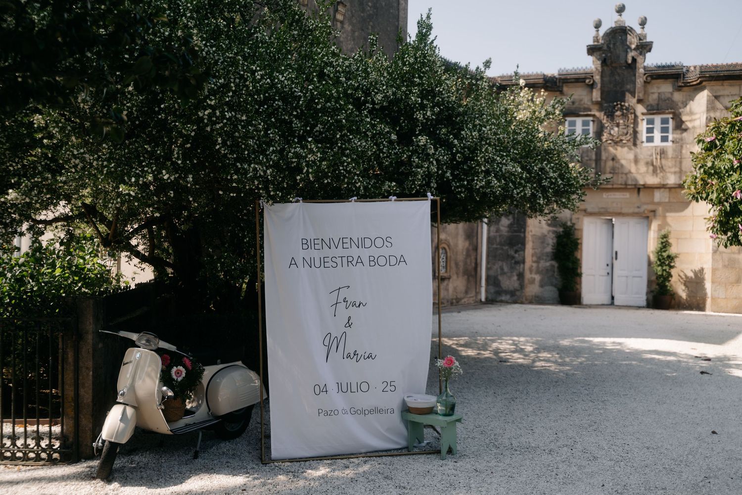A panoramic view of a rustic stone courtyard with white walls and architectural details in Mediterranean style.