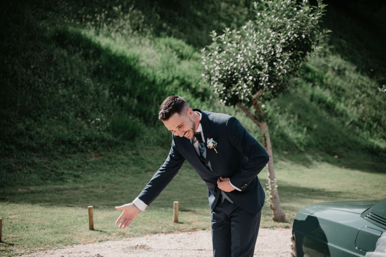 Guests seated on wooden chairs during an outdoor garden wedding ceremony.