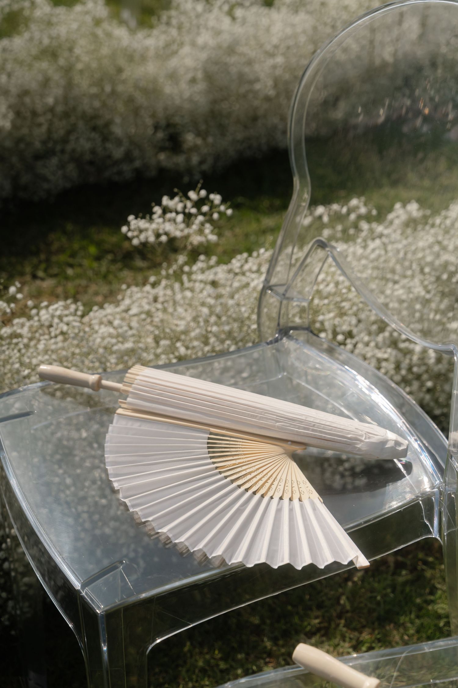 Decorative white paper fans arranged on clear acrylic display stands.