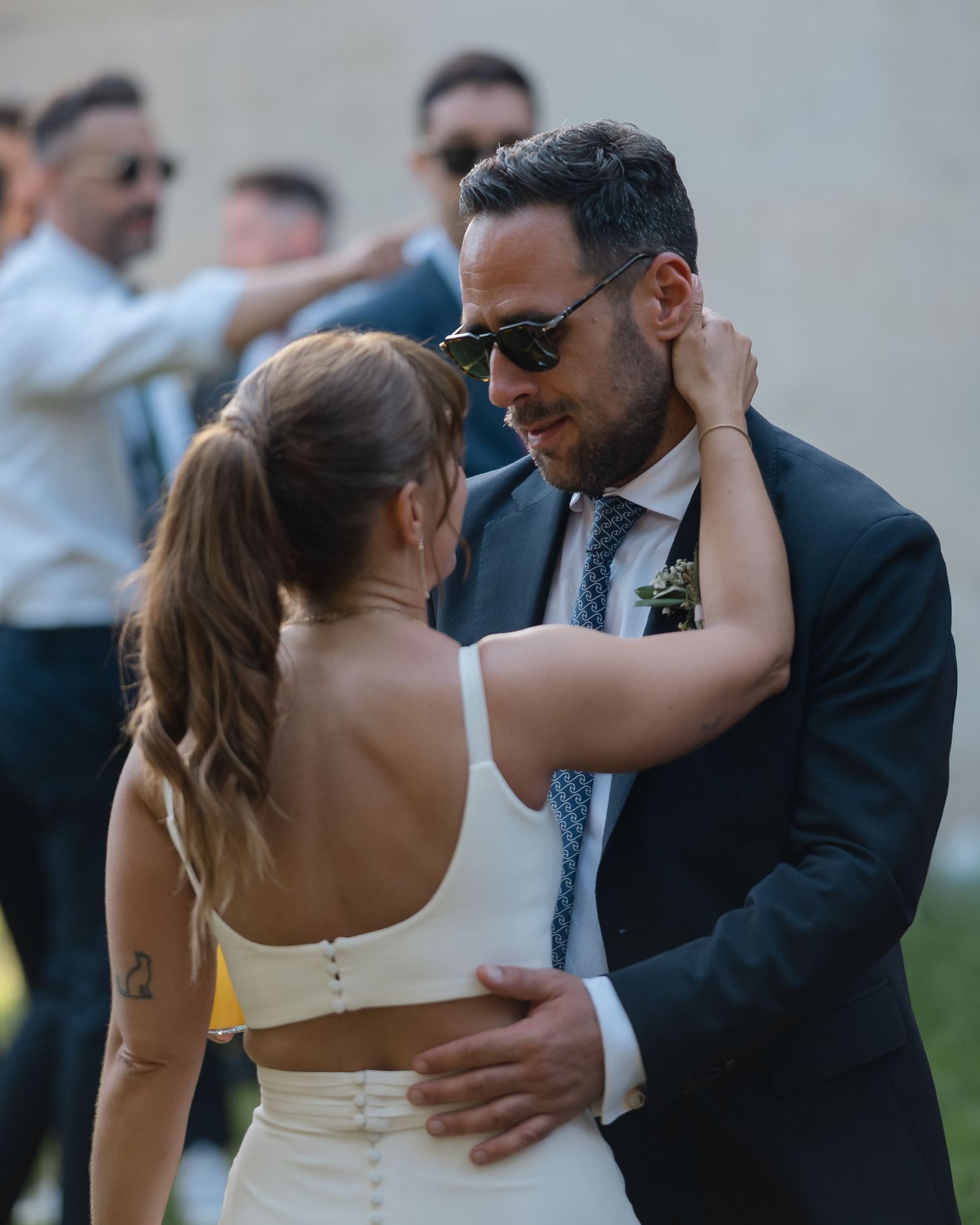Couple sharing a romantic dance moment during an outdoor wedding celebration.