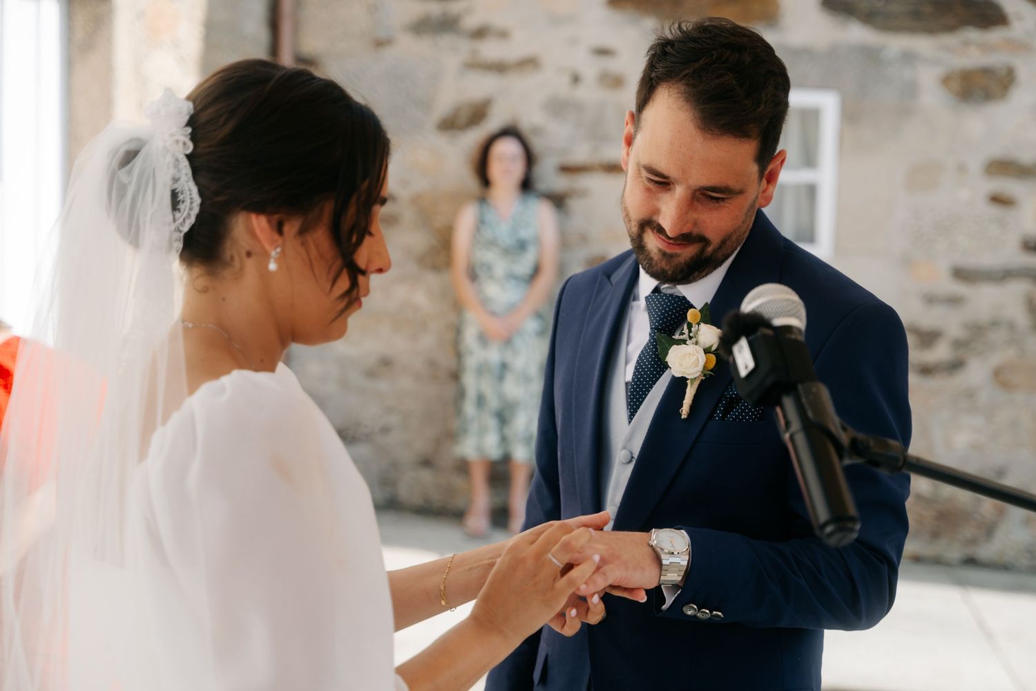 Elegant outdoor wedding celebration with guests gathered in a stone courtyard.