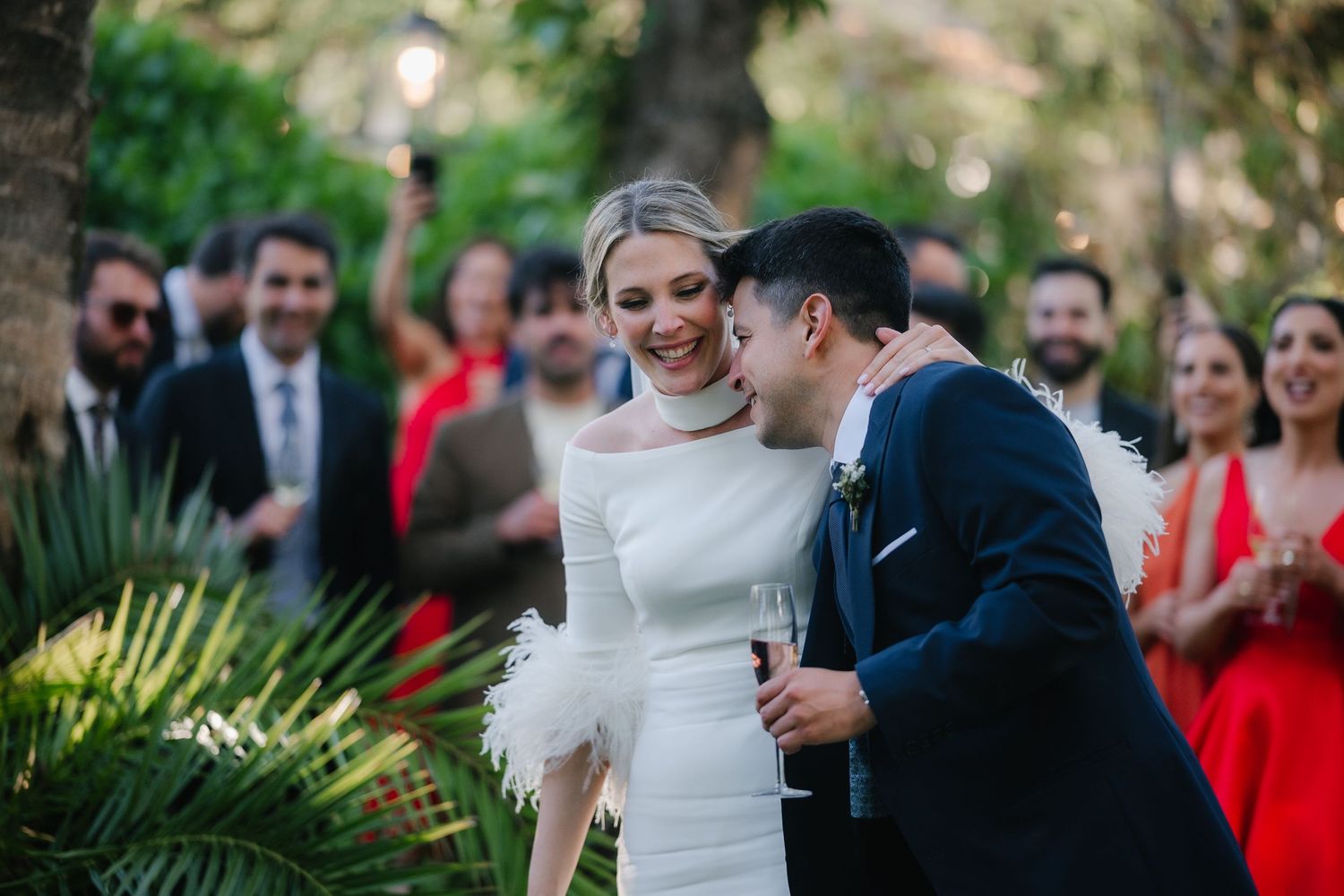 A couple shares an intimate moment during their outdoor wedding ceremony surrounded by guests.