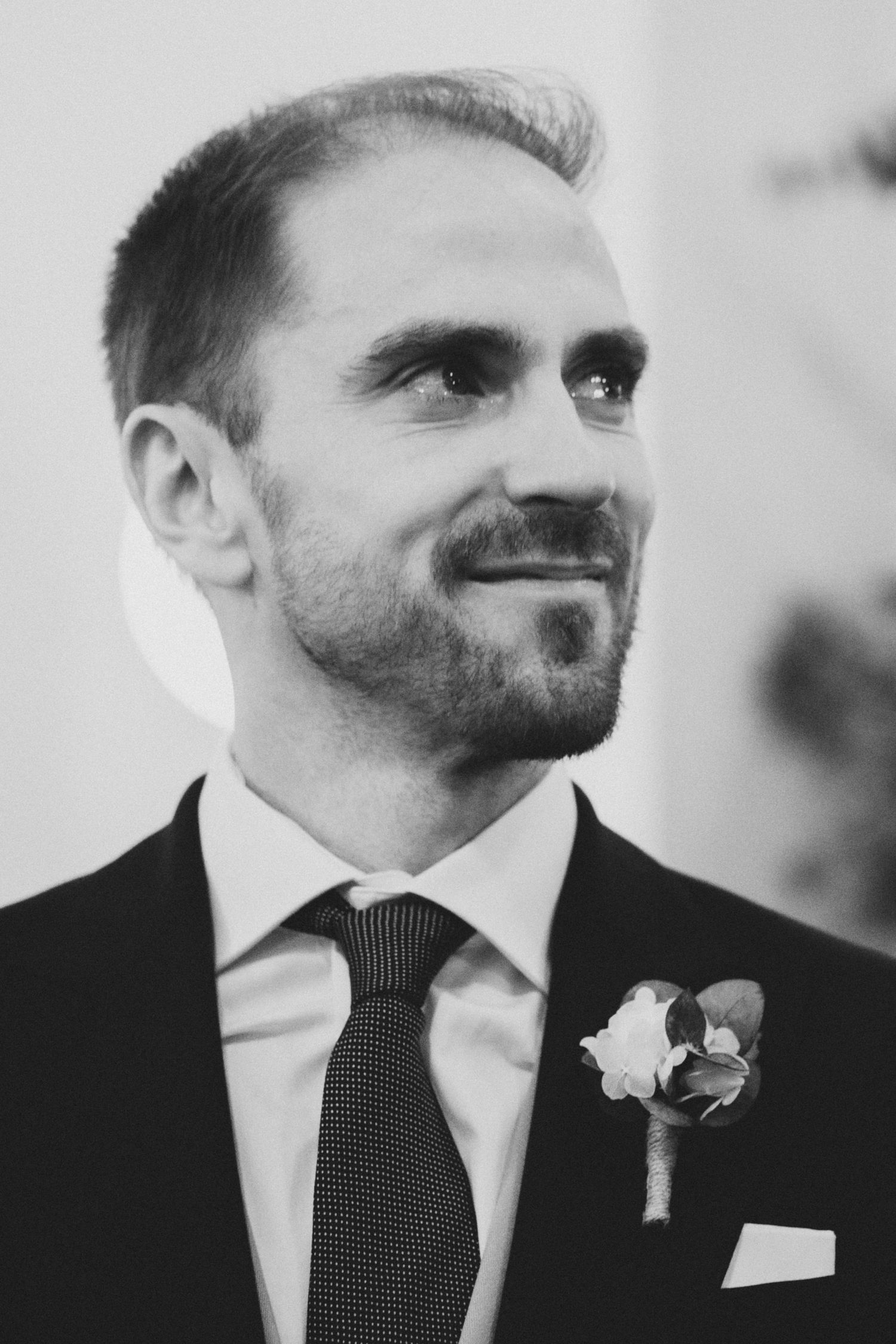 Close-up black and white portrait shots showing details of formal attire and boutonniere.
