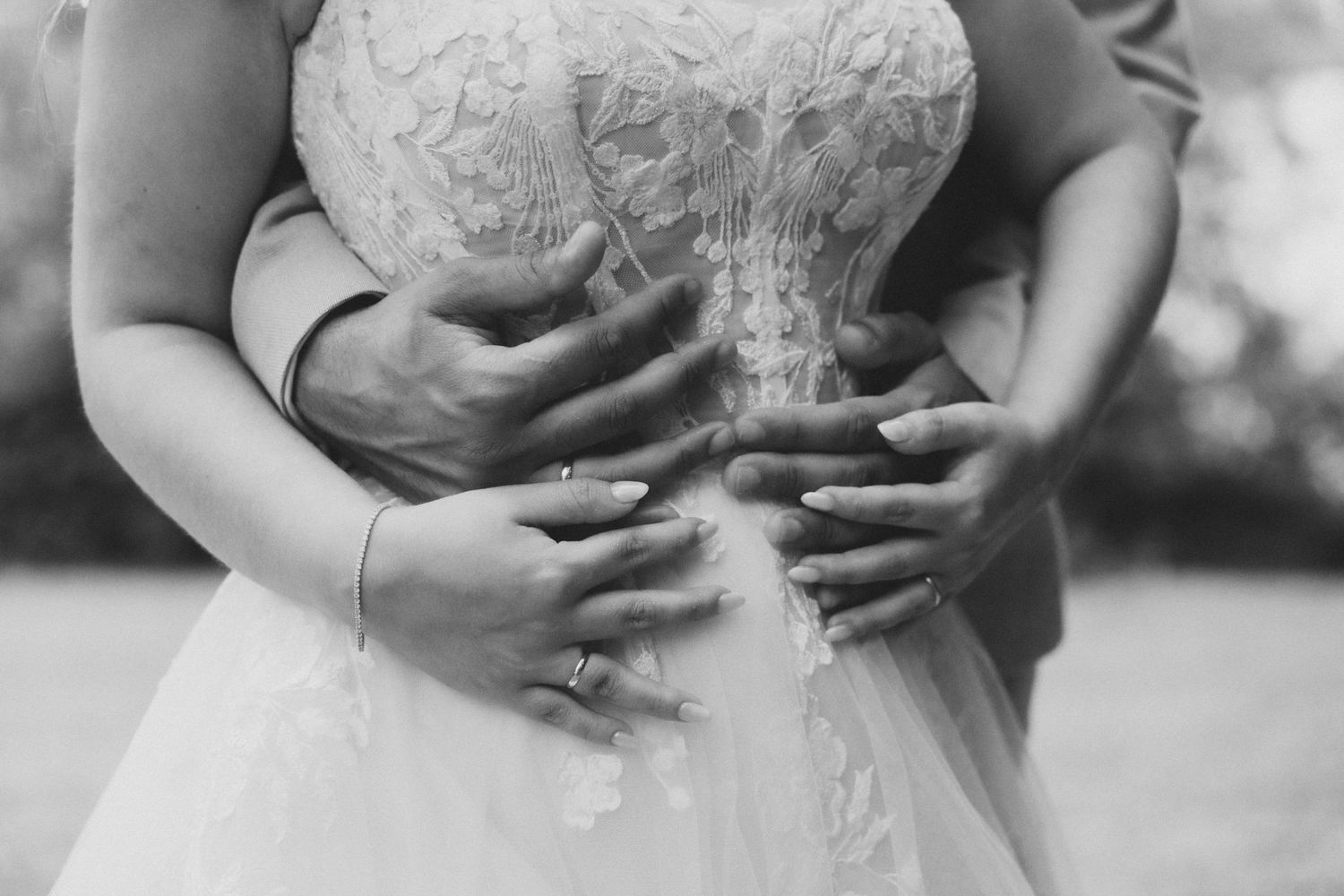 A series of black and white wedding photos showing close-up details of a lace bridal gown and bouquet.