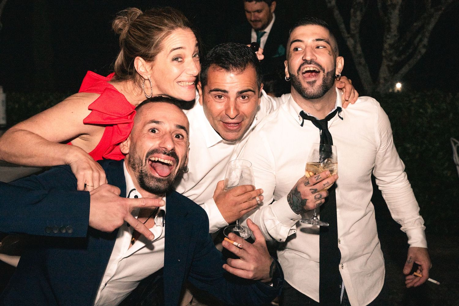 A group of people at a party laughing and having fun together while posing for candid photos.