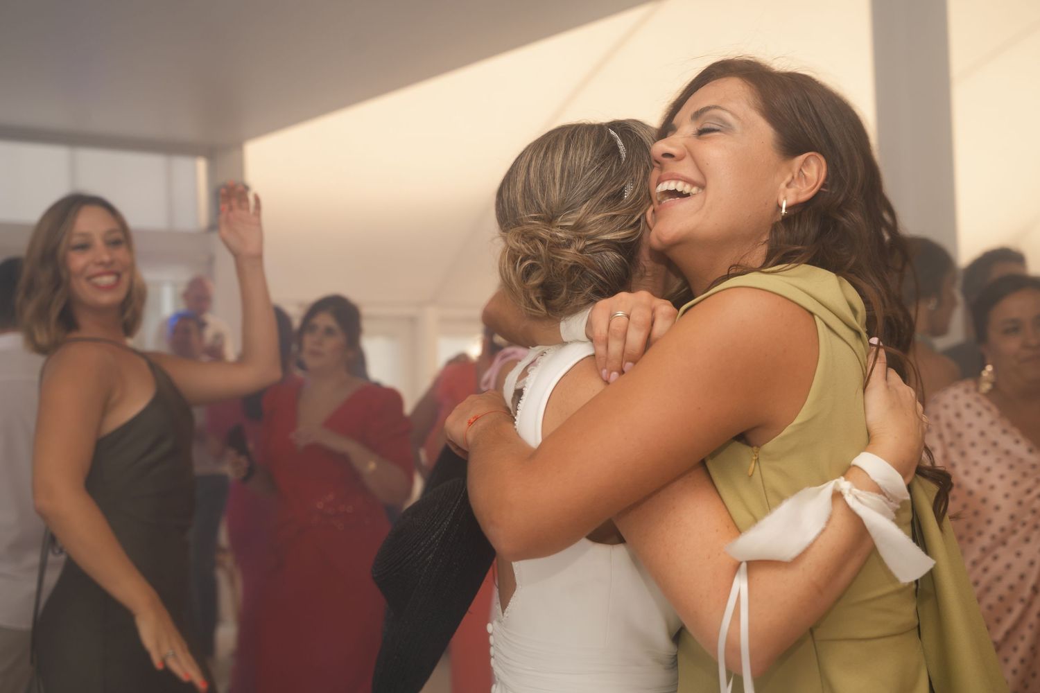 People embrace each other emotionally during what appears to be a celebratory gathering or event.