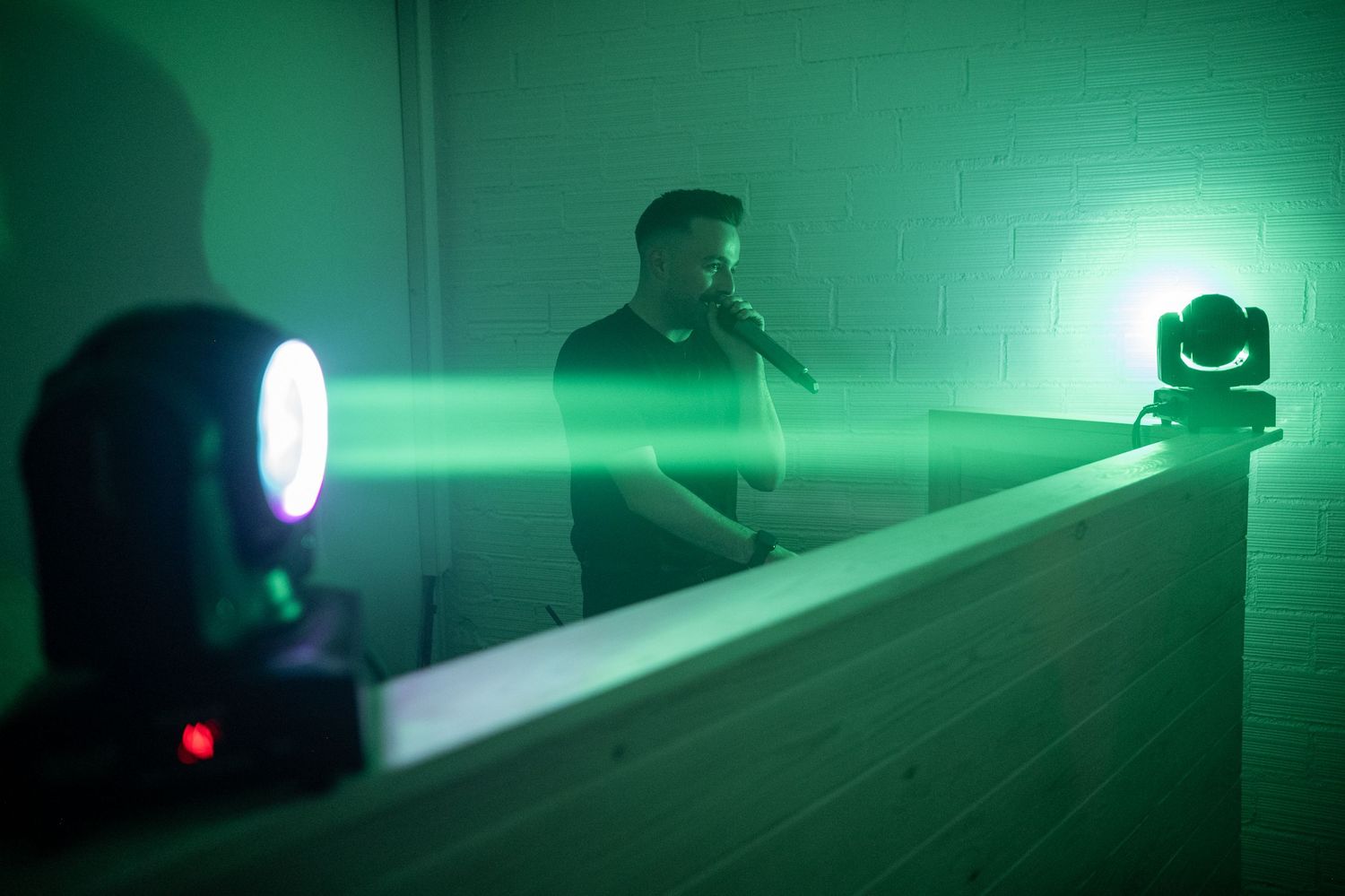 Green laser beams illuminate a dark room creating an atmospheric effect with multiple light sources.