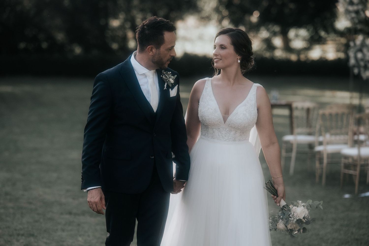 A romantic wedding couple shares an intimate moment in a garden setting during their special day celebration.