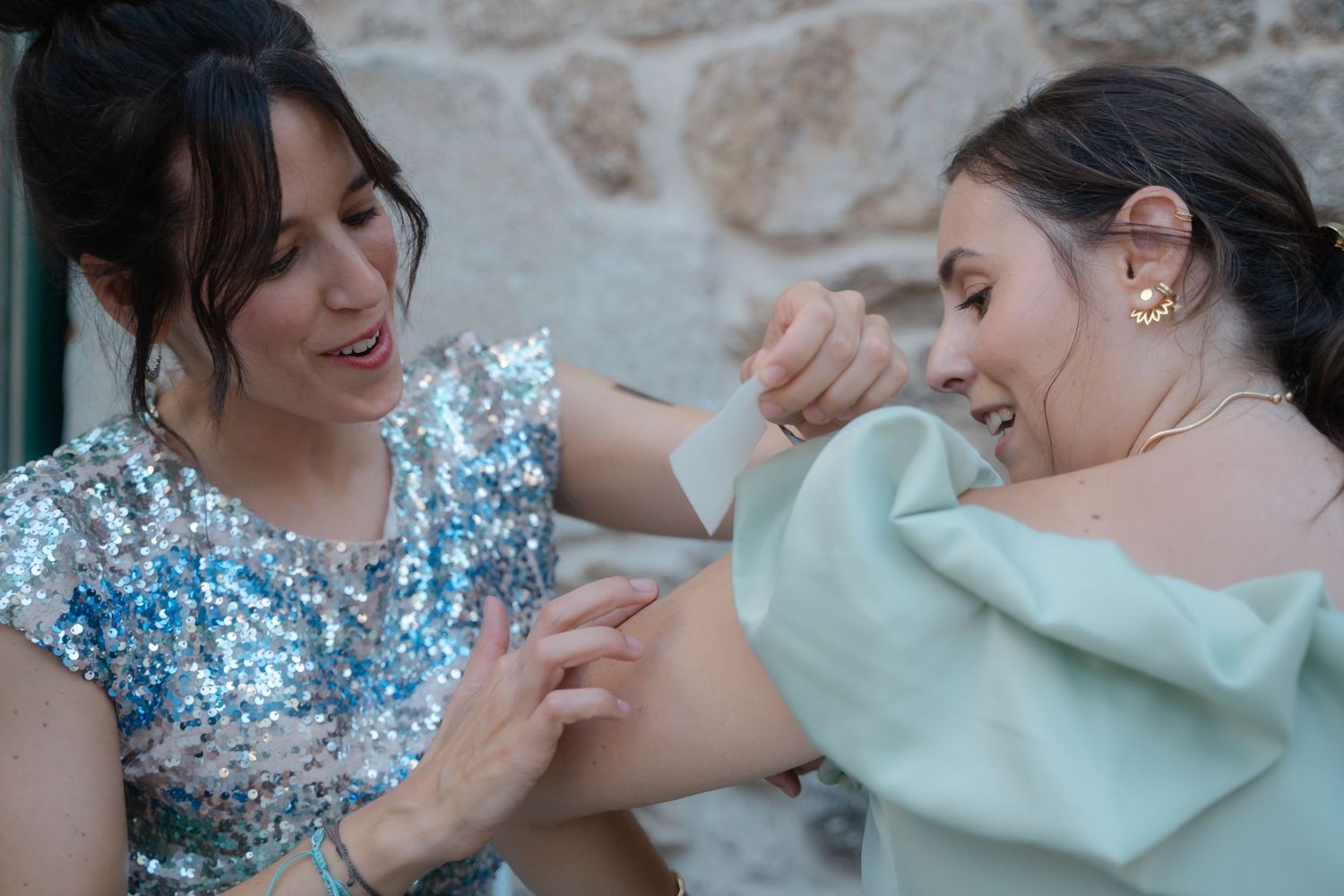 Two people share a joyful moment together while wearing sparkly blue and mint green formal attire.
