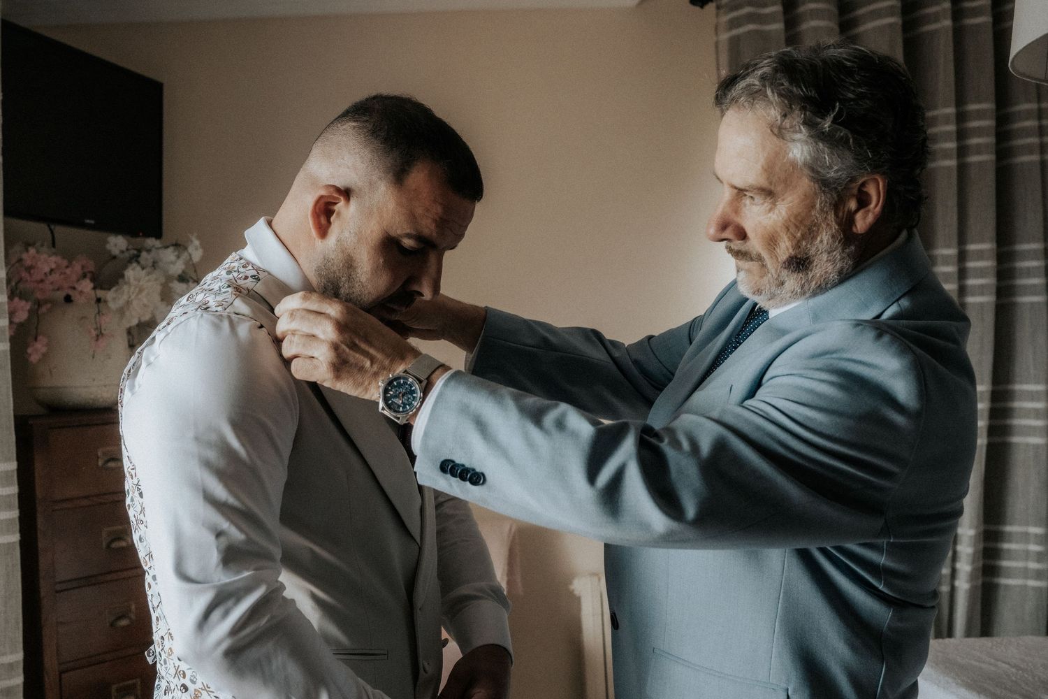 Two people in formal attire demonstrate self-defense techniques in an indoor setting.