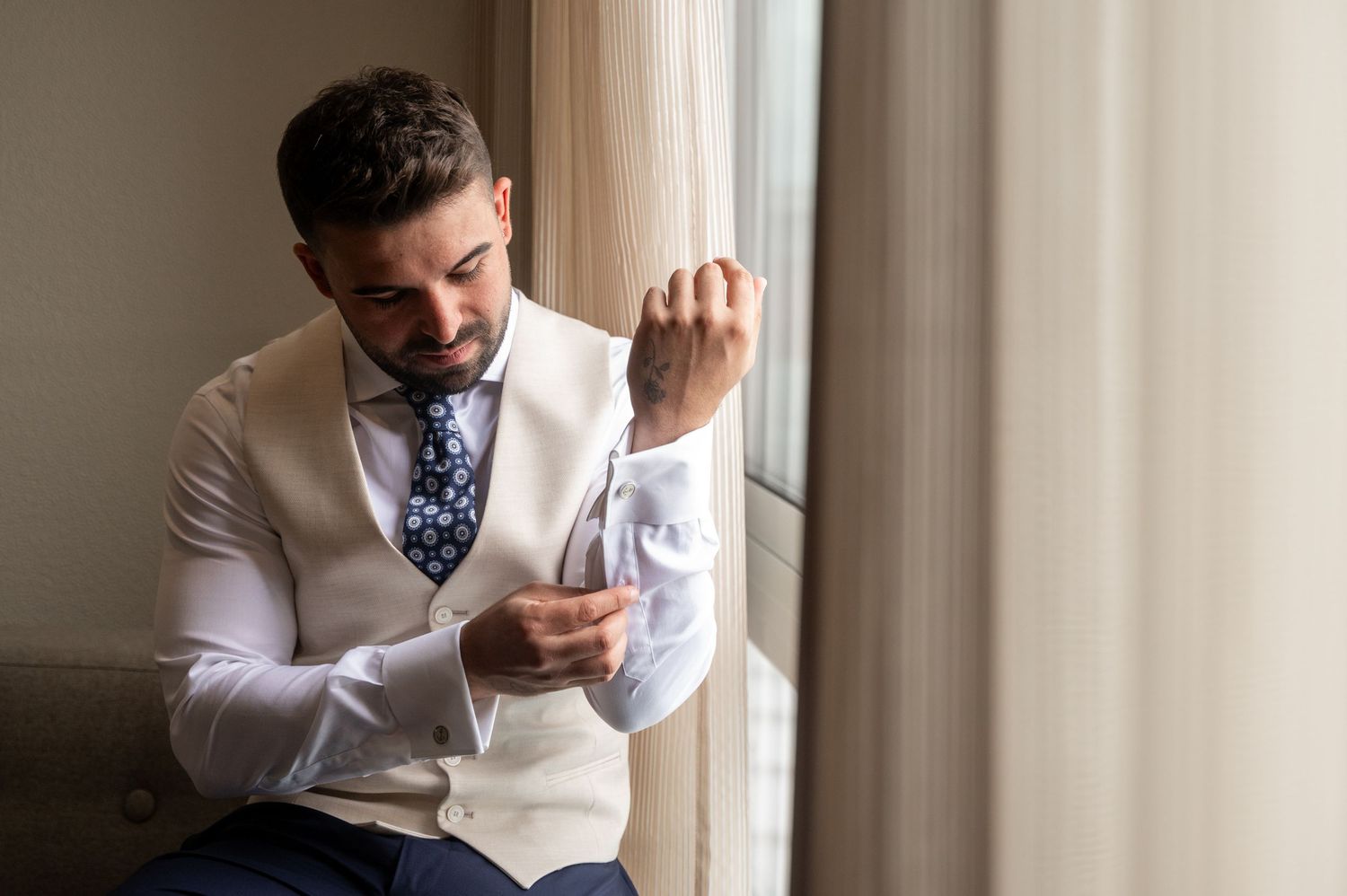 A person in a white suit and polka dot tie adjusts their collar in a collage of four similar poses.