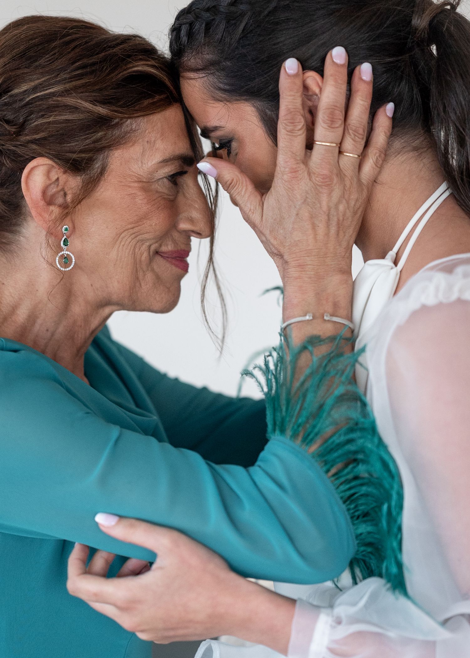 Two people in teal and white clothing share an intimate embrace in a sequence of connected photos.