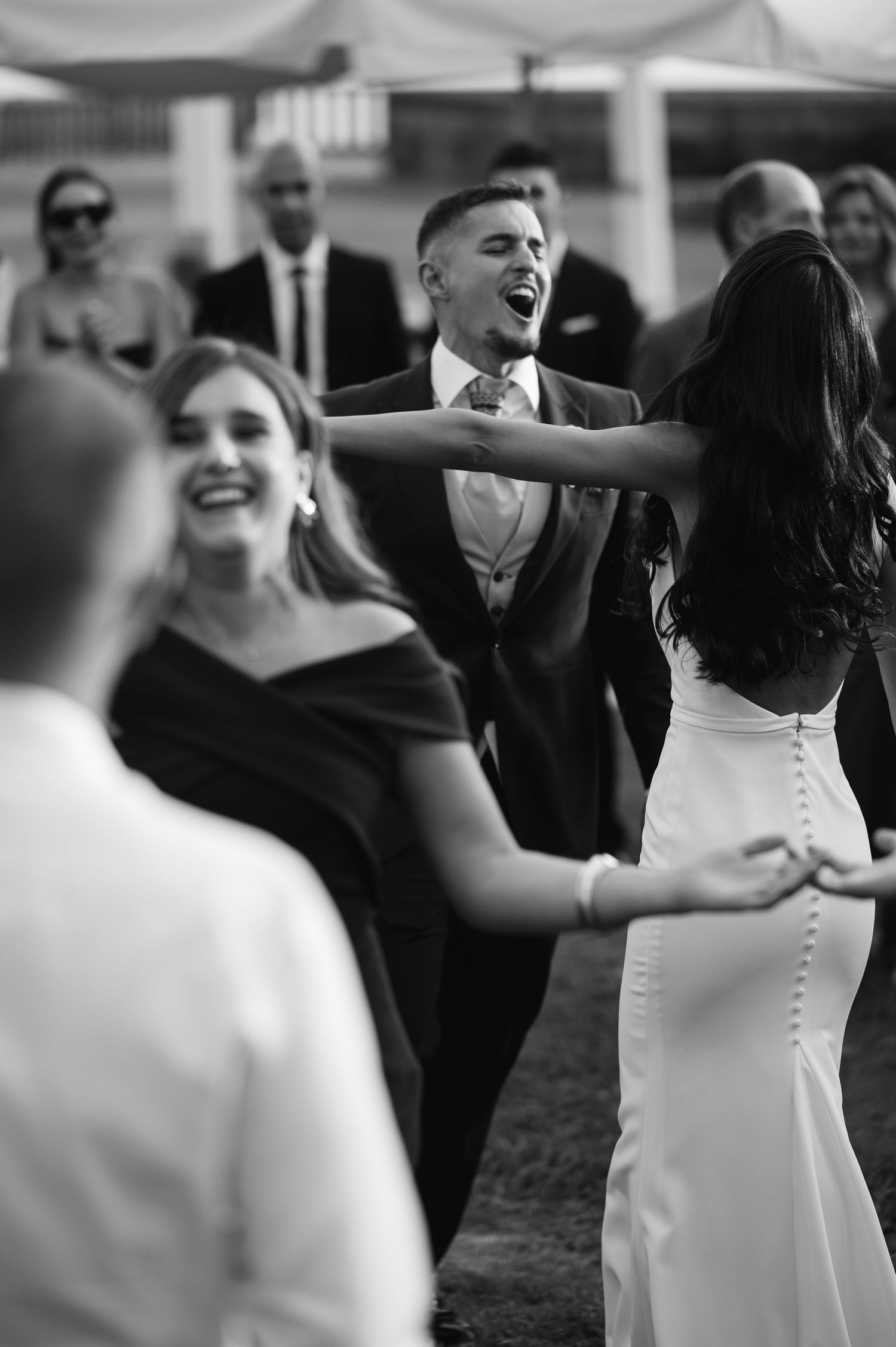 A sequence of black and white photos showing joyful dancing moments at a wedding reception.